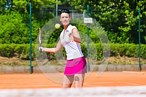 Woman playing tennis on court outdoors