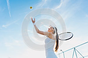 Woman playing tennis giving service