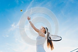 Woman playing tennis giving service