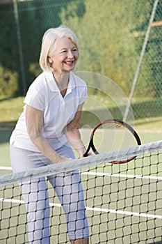 Woman playing tennis and smiling