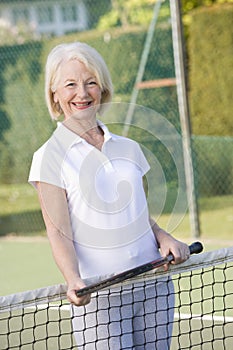 Woman playing tennis and smiling