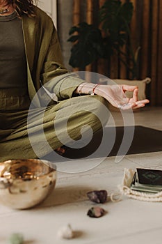 Woman playing on Tibetan singing bowl while sitting on yoga mat. Soft focus blurred and noise effect