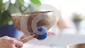 Woman playing on Tibetan singing bowl while sitting on yoga mat. Vintage tonned. stock footage. Slow Motion video. Close