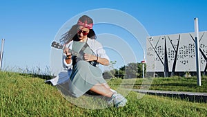 Woman playing ukulele guitar in modern park