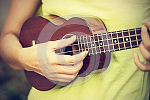 Woman playing ukulele, vintage style photo