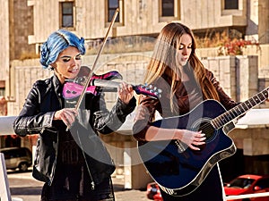 Woman playing violin and guitar