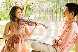 Woman playing violin with her boyfriend