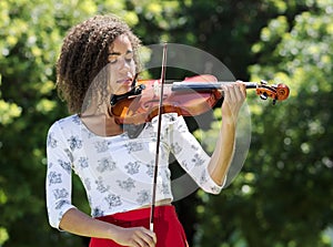 Woman playing a violin outdoors