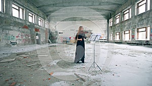 A woman is playing the violin in a stranded building