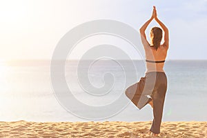Woman playing Yoga and exercise on the tropical beach in sunset