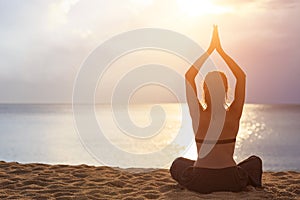 Woman playing Yoga and exercise on the tropical beach in sunset