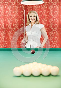 Woman plays billiards