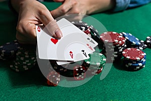 A woman plays in a casino. opening cards to raise bets. Against the background of chips. Poker victory