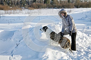 Woman plays with a dog in the winter