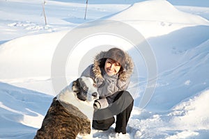 Woman plays with a dog in the winter day