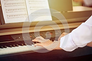 Woman plays electric piano at outdoor music performance, close up view to nimble hands