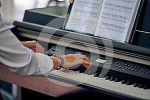 Woman plays electric piano at outdoor music performance, close up view to nimble hands