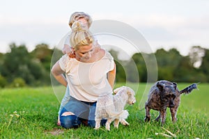 Woman plays with her son and two small dogs