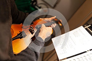 A woman plays a violin in a room