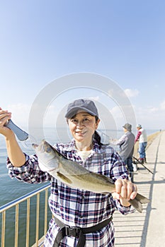 A woman pleased to catch a big fish