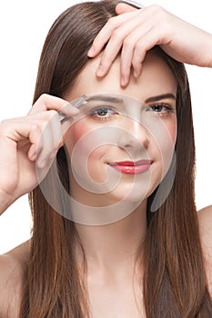 Woman plucking her eyebrows