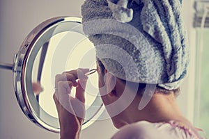 Woman plucking her eyebrows