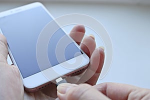 Woman plugging a USB cable into a smartphone connector to charge. Special charging connector for phone