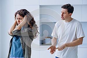 Woman plugs ears not wanting to hear husband quarrel shout