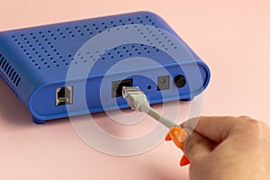 A woman plugs an Internet cable into a router. Ethernet Connection Concept