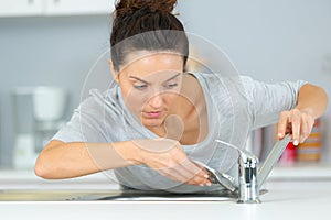 Woman plumber fixing sink