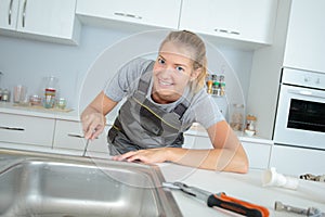 Woman plumber fixing sink