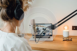 Woman podcaster streaming and broadcasting her podcast from homemade studio