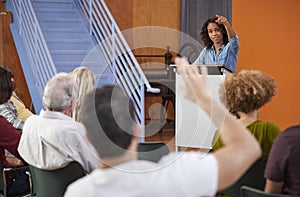 Woman At Podium Chairing Neighborhood Meeting In Community Centre