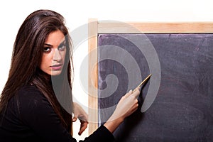 Woman pointing at a blank blackboard with a pen.
