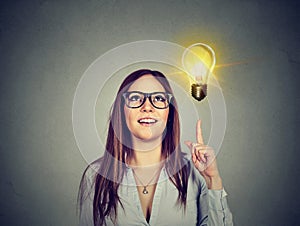 Woman pointing at bright light bulb. Success growing business concept