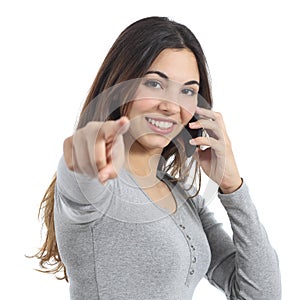 Woman pointing at camera calling on the mobile phone