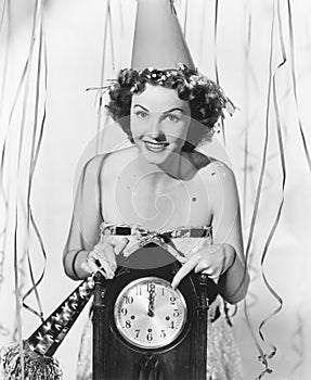 Woman pointing at the clock at midnight