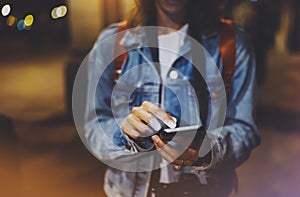 Woman pointing finger on blank screen smartphone on background bokeh light in night atmospheric city, blogger hipster using in han