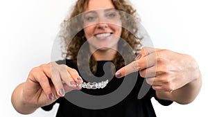 Woman pointing hand to dental aligner retainer for beautiful teeth treatment