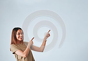 Woman, pointing hands and smile at space for mockup, studio advertising or product placement. Happy female on white