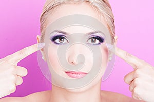 Woman pointing her eyes as professional make-up concept