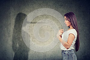 Woman pointing at herself looking at a shadow with long nose of a liar