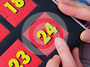 Woman pointing at the number 24 on an advent calendar