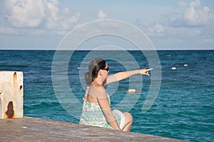 Woman pointing by the ocean