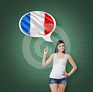 Woman is pointing out the thought bubble with French flag. Green chalk board background.