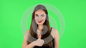 Woman pointing side hand for something then nods and shows thumb like. Green screen