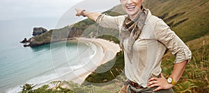 Woman pointing on something in front of ocean view landscape