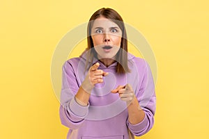 Woman pointing to camera with surprised shocked expression and open mouth.