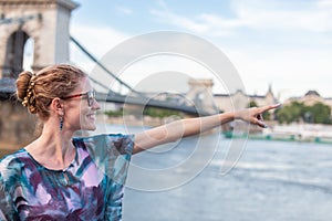 Woman pointing to Chain Bridge at Budapest, Hungary