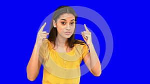 Woman pointing to her temples on blue screen